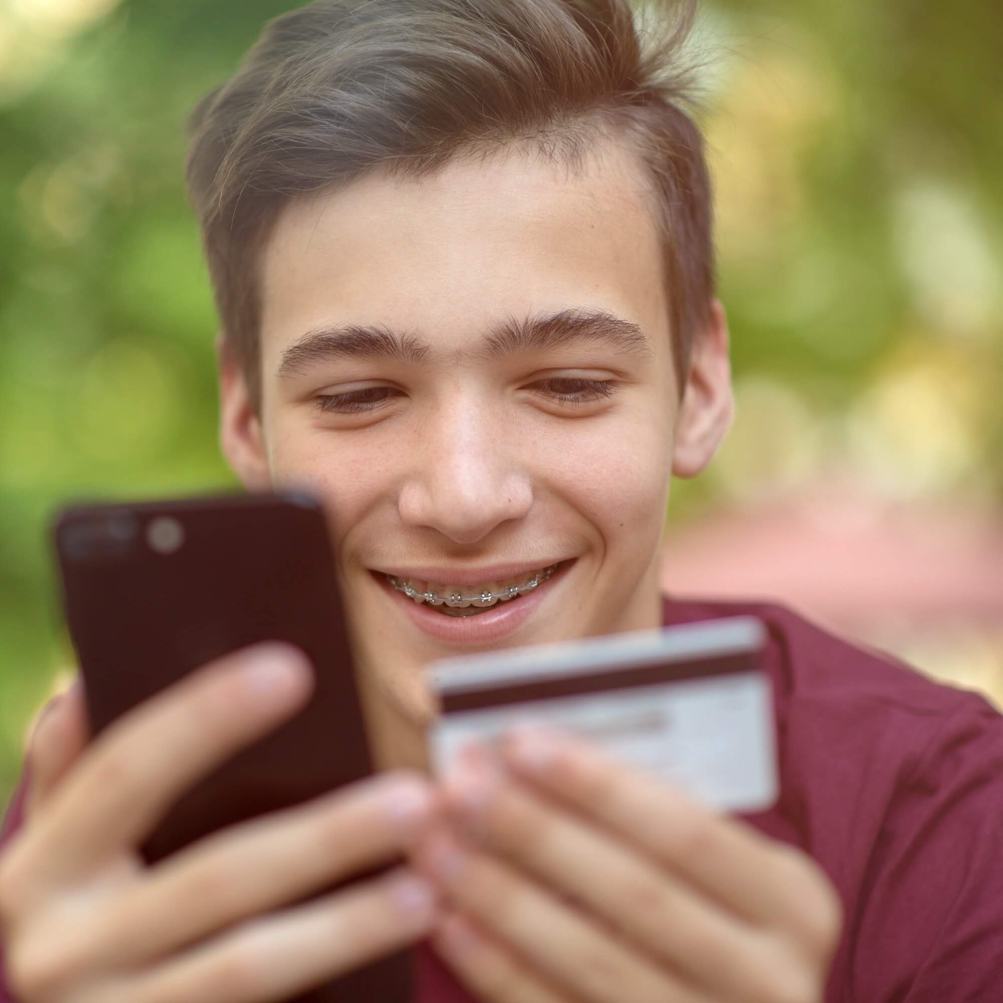 happy young man is using smartphone and bank card for online shopping 1